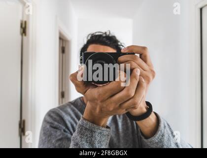 Junger Fotograf, der ein Selfie am Spiegel macht Stockfoto