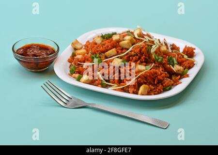 Schezwan paneer gebratener Reis mit schezwan-Sauce, chinesischer gebratener Reis mit paneer, garniert mit Frühlingszwiebel und Kohl Stockfoto