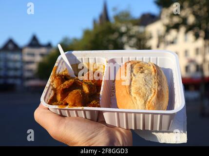 Deutsche Küche - Currywurst in Köln, Deutschland. Currywurst in einer deutschen Wurst mit Currysauce, in der Regel mit einem Brötchen gegessen. Stockfoto