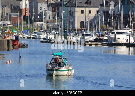 Aberystwyth Wales Vereinigtes Königreich Wetter 14. April 2021 . Ein sonniger Tag an der Westküste von Wales, an dem sich die Menschen versammelten, um das glitzernde blaue Meer und einen farbenfrohen Yachthafen zu sehen, während viele Boote bei Flut aus dem Hafen segeln, Quelle: mike davies/Alamy Live News Stockfoto