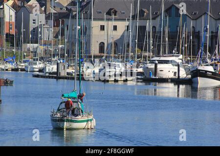 Aberystwyth Wales Vereinigtes Königreich Wetter 14. April 2021 . Ein sonniger Tag an der Westküste von Wales, an dem sich die Menschen versammelten, um das glitzernde blaue Meer und einen farbenfrohen Yachthafen zu sehen, während viele Boote bei Flut aus dem Hafen segeln, Quelle: mike davies/Alamy Live News Stockfoto