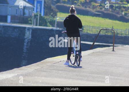 Aberystwyth Wales Vereinigtes Königreich Wetter 14. April 2021 . Ein sonniger Tag an der Westküste von Wales, an dem sich die Menschen versammelten, um das glitzernde blaue Meer und einen farbenfrohen Yachthafen zu sehen, während viele Boote bei Flut aus dem Hafen segeln, Quelle: mike davies/Alamy Live News Stockfoto