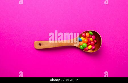 Mehrfarbiges Bonbon-Set mit einem Holzlöffel Stockfoto