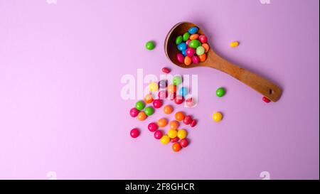 Mehrfarbiges Bonbon-Set mit einem Holzlöffel Stockfoto