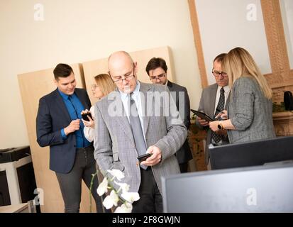 Geschäftsmann Architekt mit Mobiltelefon mit Kollegen hinter im Büro Stockfoto