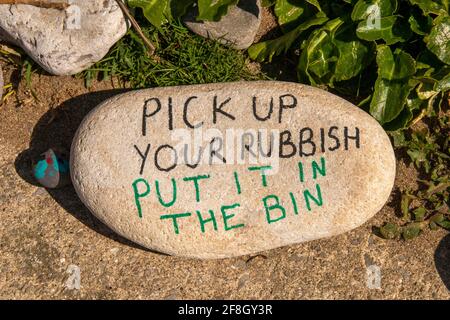 Swansea, Großbritannien. April 2021. Ein handgeschriebener Kieselstein, der die Menschen daran erinnert, ihren Müll heute Nachmittag am Strand in der Rotherslade Bay auf der Gower Peninsula in der Nähe von Swansea abzuholen. Quelle: Phil Rees/Alamy Live News Stockfoto