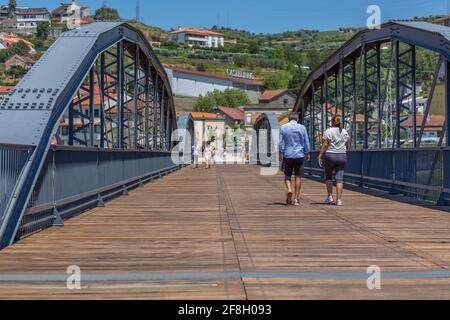 Regua / Portugal - 10/02/2020 : Blick auf ein älteres Paar von Touristen auf dem Rücken, Spaziergang durch die Metallbrücke der Stadt Peso Regua, andere b Stockfoto