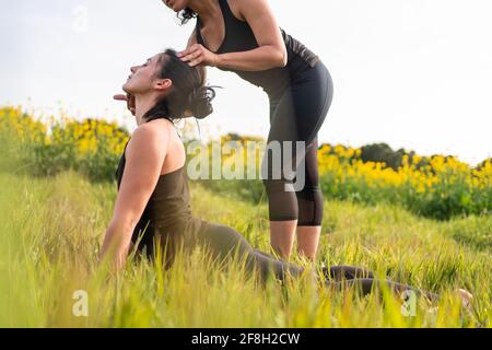 Yoga-Lehrer unterrichtet Schüler, der gerade erst beginnt in Natur Stockfoto