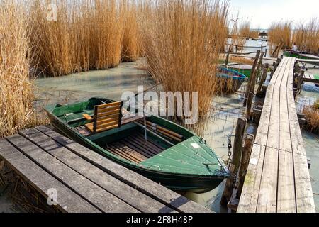 Plattensee mit einem Boot im Schilf Badacsony Hügel Hintergrund. Stockfoto