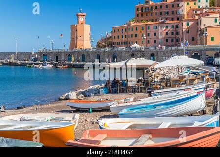 Hafen von Rio Marina, auf der Insel Elba, historische Gebäude und Fischerboote im Hafen. Stockfoto