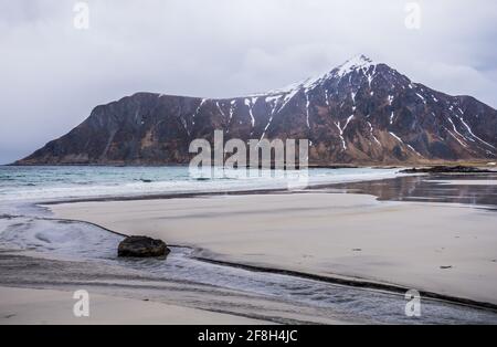 Skagsanden Beach Bay, Lofoten Islands, Norwegen. Felsküste des Fjords im norwegischen Meer. Dramatischer Wolkenhimmel, keine Menschen Stockfoto