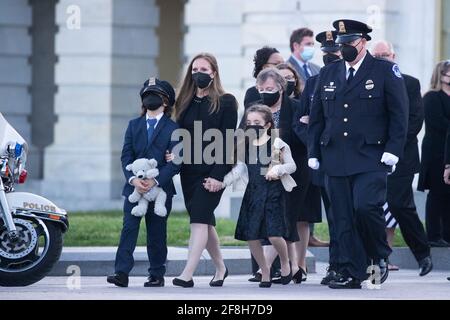 Die Familie des US-Polizeibeamten William Evans, der Frau Shannon Terranova (C), ihres neunjährigen Sohnes Logan (C-L) und ihrer siebenjährigen Tochter Abigail (C-R); Gehen Sie mit anderen Familienmitgliedern, Freunden und Polizeibeamten hinaus, um sie zu beobachten, bevor die Schatulle von Officer Evans von einem gemeinsamen Ehrengarde über die Schritte der Ostfront des US-Kapitols getragen wird, nachdem er zu Ehren in der Capitol Rotunda in Washington, DC, USA, gelegen hatte, 13. April 2021. Für Officer Evans fand eine „Tribute and Lying in Honor Ceremony“ statt, der getötet und ein weiterer Offizier im Dienst verletzt wurde, als ein Verdächtiger ein Veh rammte Stockfoto