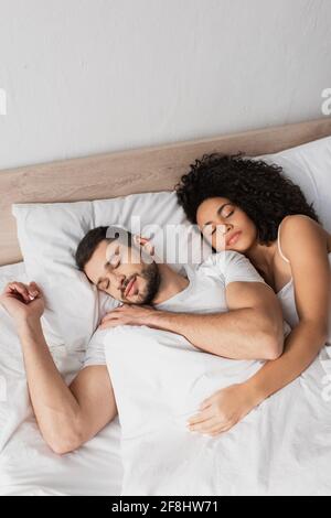 Blick auf das multiethnische Paar, das im Bett schläft Stockfoto