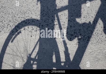 Schatten eines Radfahrers mit Fuß auf dem Pedal Stockfoto