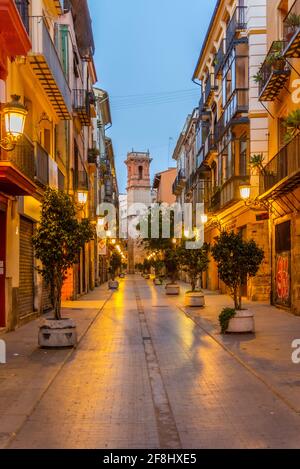 Blick bei Sonnenaufgang auf die Straße Carrer dels Serrans, die zum Torre de Sant Bartomeu Turm in Valencia, Spanien führt Stockfoto