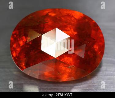Natürlicher Edelstein orange spessartine Granat auf grauem Hintergrund. Spessartite Granat Stockfoto
