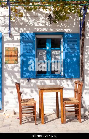 Traditionelles Kafenio (Café) auf der griechischen Insel Paros im Dorf Lefkes mit seinen weiß getünchten Wänden und traditionellen Holzstühlen und -Tisch Stockfoto