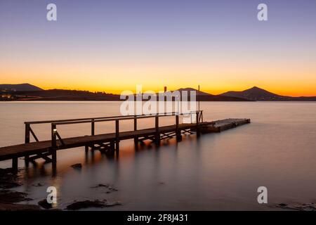 Eine alte hölzerne Plattform als Landschaft des Sonnenuntergangs an einem Strand in Paros Insel, Kykladen Inseln, Ägäis, Griechenland, Europa. Stockfoto