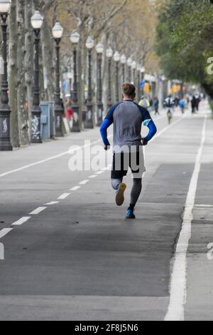 Rückansicht eines jungen Mannes, der entlang der Avenue läuft. Stockfoto