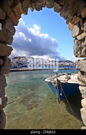 Naoussa Dorf, auf der Insel Paros, Teilansicht des Fischerhafens durch ein Steinfenster des Dorfs Burg. Stockfoto