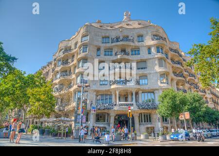 BARCELONA, SPANIEN, 30. JUNI 2019: Menschen passieren auf einer Straße vor dem Gebäude La Pedrera in Barcelona, Spanien Stockfoto