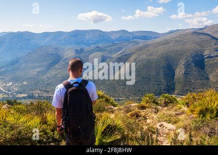 Junger Bergsteiger, der auf einem Felsen steht Stockfoto