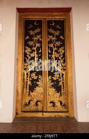 Bangkok, Thailand - 25. März 2018: Riesige goldene Tür in der Phutthaisawan Hall, dekoriert mit prächtigen Pflanzenmotiven, auf dem Gelände der Bangkok Natio Stockfoto