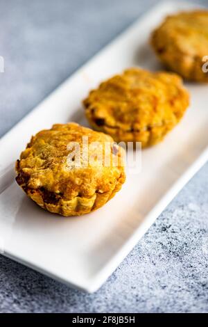 Herzhafte Fleischpasteten mit Käse auf einem Teller Stockfoto