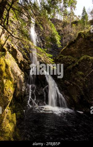 Blick auf die Basis der Plodda-Wasserfälle, einem Wasserfall in glen Affric Schottland, an einem sonnigen Tag, der in eine moosbedeckte Schlucht stürzt Stockfoto