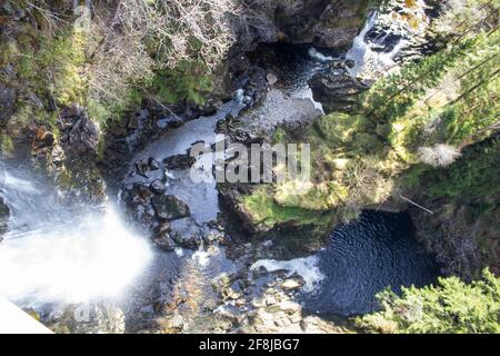 Die majestätischen Plodda Falls, wo sie in eine tiefe Schlucht in Glenn Afric, Schottland, stürzen, wie von der Spitze der Wasserfälle gesehen Stockfoto