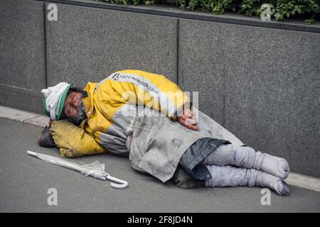 Obdachlose japanische Männer legten sich auf der Straße neben einem Regenschirm nieder, Aoyama, Tokio, Japan Stockfoto