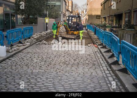 Arbeiter, die eine gepflasterter Straße schaffen Stockfoto