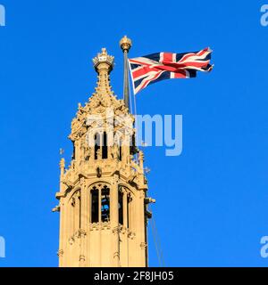 Die britische Flagge von Union Jack fliegt gegen den blauen Himmel am Houses of Parliament in Westminster, London, England, Großbritannien Stockfoto