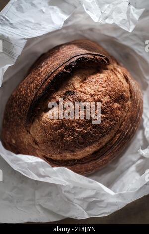 Laib frisch gebackene Weizensauerteigbrot in Geschenkpapier Stockfoto