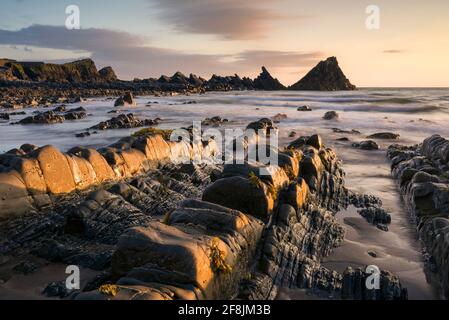 Der exponierte Strand bei Ebbe am Hartland Quay im Gebiet von North Devon von herausragender natürlicher Schönheit bei Sonnenuntergang, England.