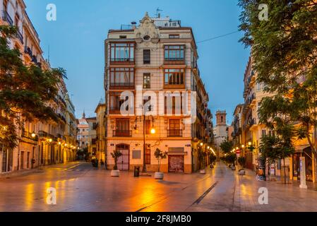 VALENCIA, SPANIEN, 18. JUNI 2019: Sonnenaufgang über der Straße Carrer dels Serrans, die zum Turm Torre de Sant Bartomeu in Valencia, Spanien führt Stockfoto