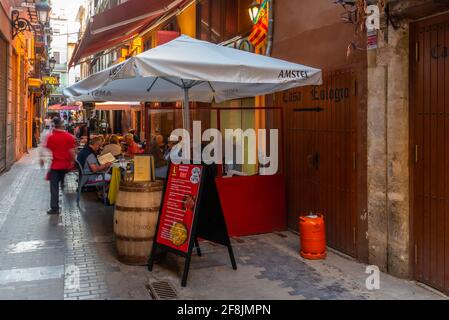 VALENCIA, SPANIEN, 17. JUNI 2019: In einer engen Straße im Zentrum von Valencia, Spanien, essen die Menschen Stockfoto