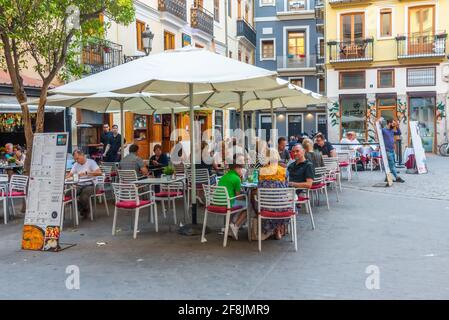 VALENCIA, SPANIEN, 17. JUNI 2019: In einer engen Straße im Zentrum von Valencia, Spanien, essen die Menschen Stockfoto