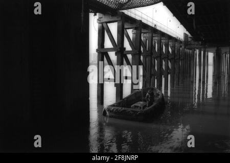 Arbeiter von Woolwich Ferry London inspizieren die Holzstruktur des Docks vom Wasser aus. Stockfoto