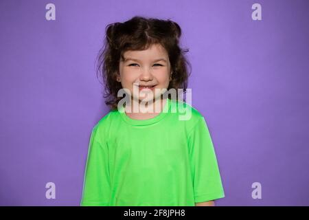 Studio-Aufnahme von jungen schönen lächelnden Mädchen 4-5 Jahre auf lila Hintergrund, verspotten Stockfoto