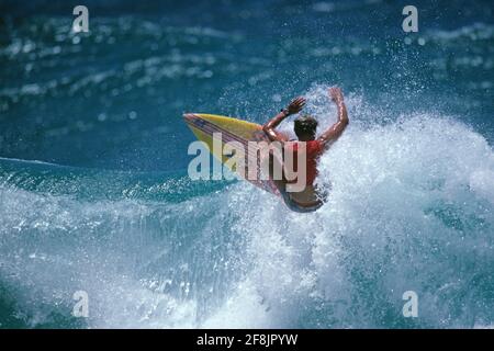 Surfen. Männlicher Surfer auf dem Kamm einer Welle. Stockfoto