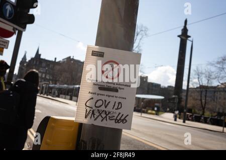 Edinburgh, Großbritannien, 14. April 2021. Anti-Covid-Impfstoff-Graffiti, ÒCovid VAXX = 666Ó, auf der Straße in Edinburgh, Schottland, abgekratzt. Mehr als 2,6 Millionen Schotten hatten jetzt während der aktuellen Gesundheitspandemie die erste Dosis des Covid-19-Coronavirus-Impfstoffs. Foto: Jeremy Sutton-Hibbert/Alamy Live News. Stockfoto