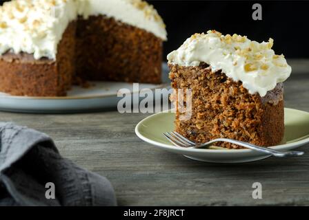 Ein hausgemachter glutenfreier Karotten- und Walnusskuchen. Dieser feuchte Kuchen hat einen köstlichen Frischkäse-Belag und wurde mit glutenfreien Zutaten hergestellt Stockfoto