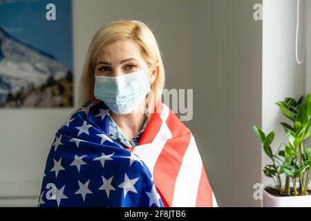 Frau trägt Maske vor den USA Flagge Wahlen während Covid Stockfoto