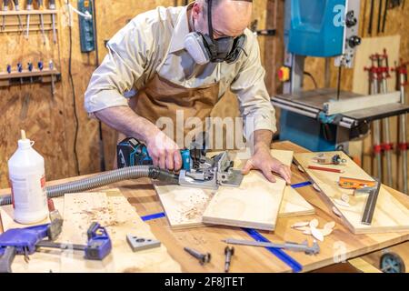 Zimmermann bei der Arbeit in seiner Werkstatt mit einem Keksjointer Stockfoto