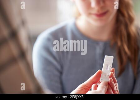 Mutter Und Tochter, Die Einen Positiven Schnellen Lateralen Flow-Test Betrachten Für Covid-19 Auf Tochter Zu Hause Stockfoto