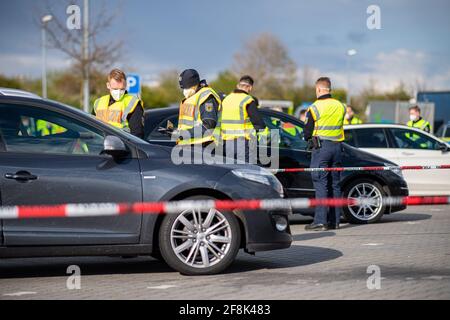 Bad Bentheim, Deutschland. April 2021. Beamte der Bundespolizei stehen hinter einer Schranke und kontrollieren kurz nach der deutsch-niederländischen Grenze mehrere Fahrzeuge auf einem Parkplatz auf der A 30. Die Bundespolizei führte gemeinsam mit ihren Kollegen der Niedersächsischen Landespolizei einen Großscheck an der A 30 an der deutsch-niederländischen Grenze durch. Der Schwerpunkt der groß angelegten Kontrolloperation liegt auf der Bekämpfung der grenzüberschreitenden Kriminalität. Quelle: Guido Kirchner/dpa/Alamy Live News Stockfoto