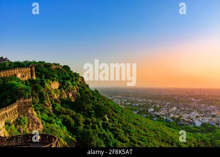 Blick während des Sonnenuntergangs von Chittor oder Chittorgarh Fort mit der Stadt im Hintergrund. Es ist eine der größten Festungen in Indien und gehört zum UNESCO-Welterbe Stockfoto