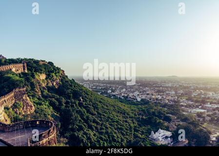 Blick während des Sonnenuntergangs von Chittor oder Chittorgarh Fort mit der Stadt im Hintergrund. Es ist eine der größten Festungen in Indien und gehört zum UNESCO-Welterbe Stockfoto