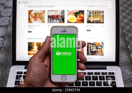 Spanien. April 2021. In dieser Abbildung wird die TheFork-App auf einem Smartphone-Bildschirm angezeigt, während im Hintergrund eine TheFork-Website auf einem Laptop angezeigt wird. (Foto von Thiago Prudencio/SOPA Images/Sipa USA) Quelle: SIPA USA/Alamy Live News Stockfoto